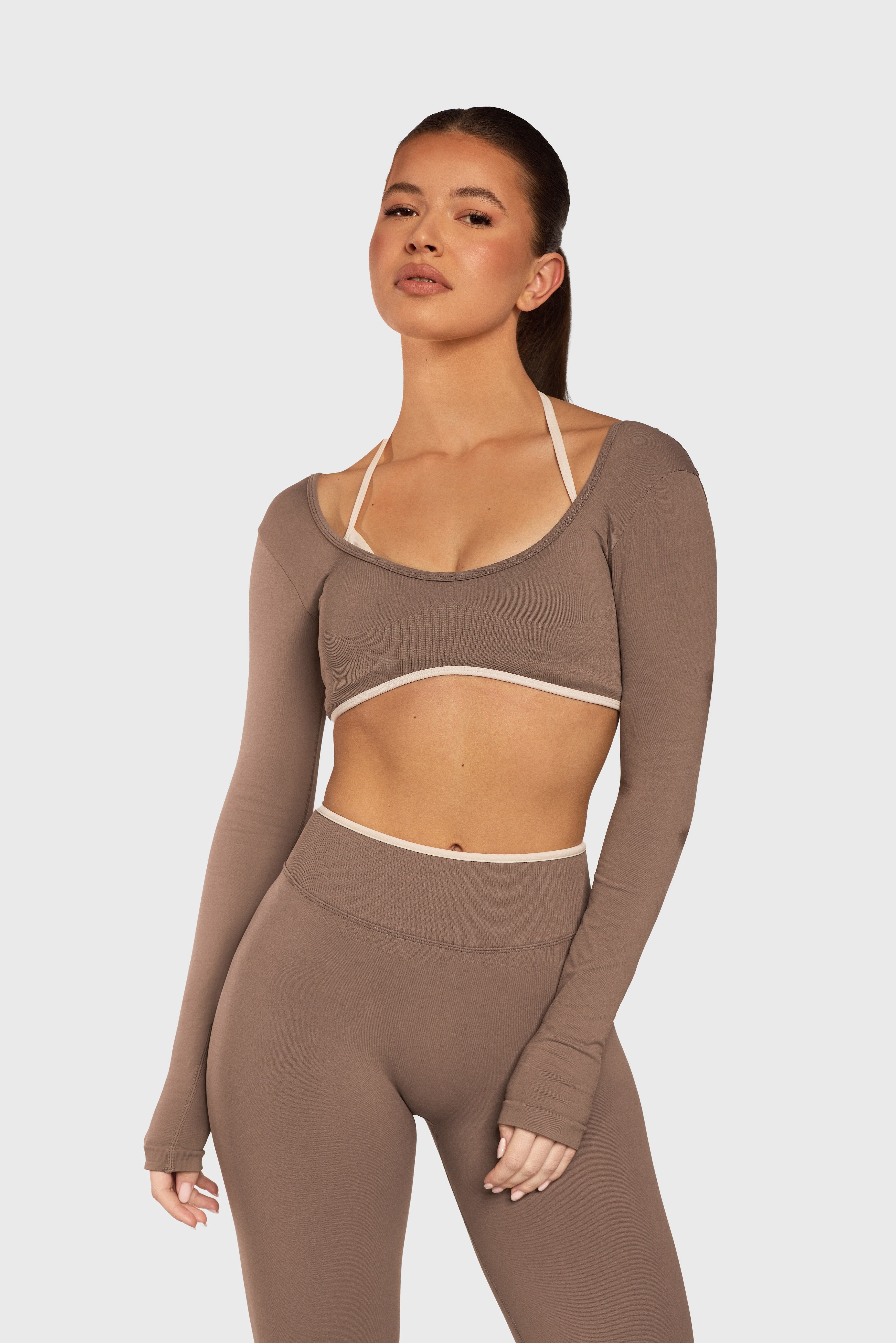 Model draagt de Mocha Sculpt Seamless Long Sleeve Top en Legging van Gymforce.