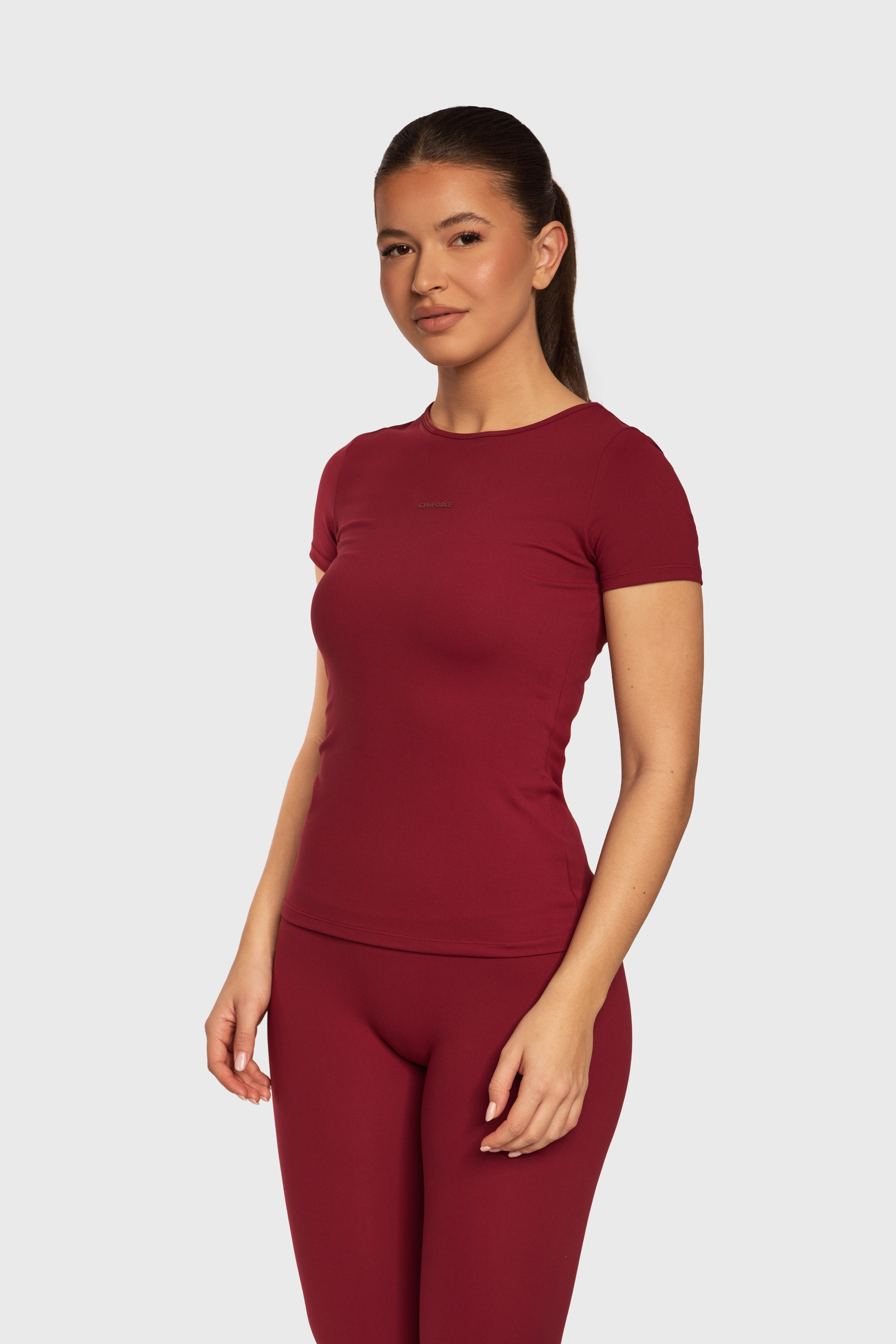 Zijaanzicht van het Burgundy Contour T Shirt en de Legging van Gymforce.