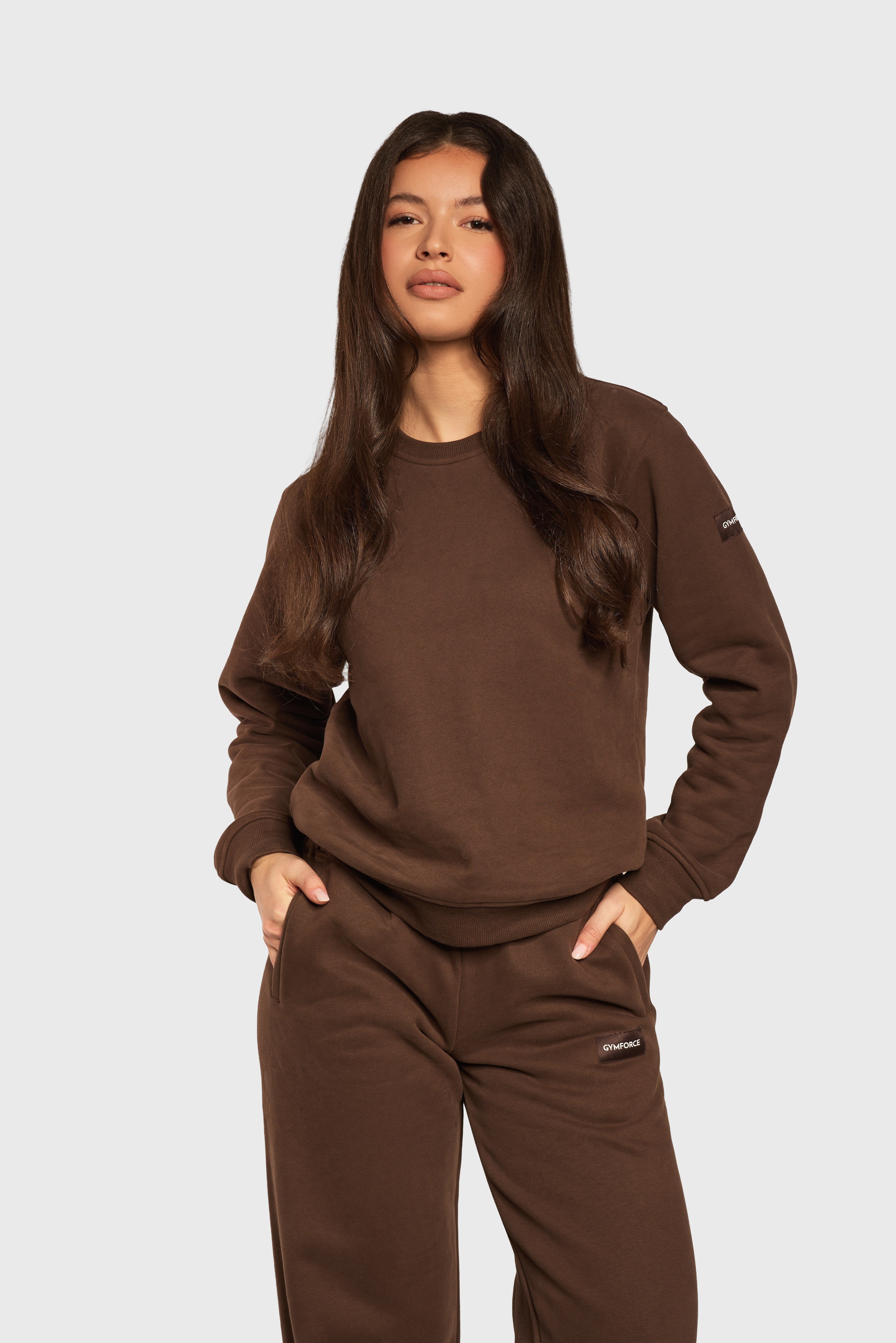 Model draagt de Soft Lounge Sweater en Wide Leg Jogger van Gymforce in donkerbruin.