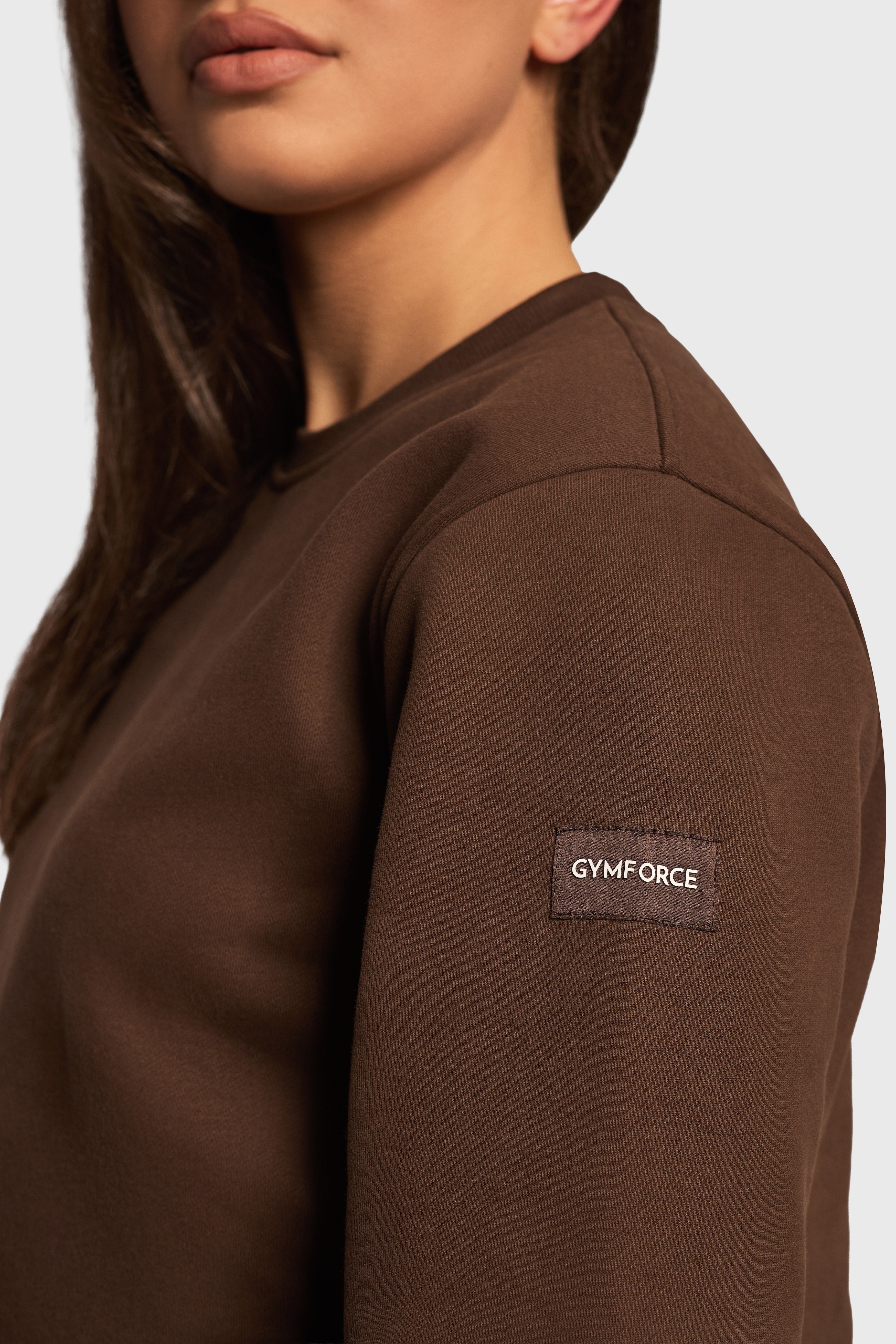 Detail van de Soft Lounge Sweater van Gymforce met logo patch.