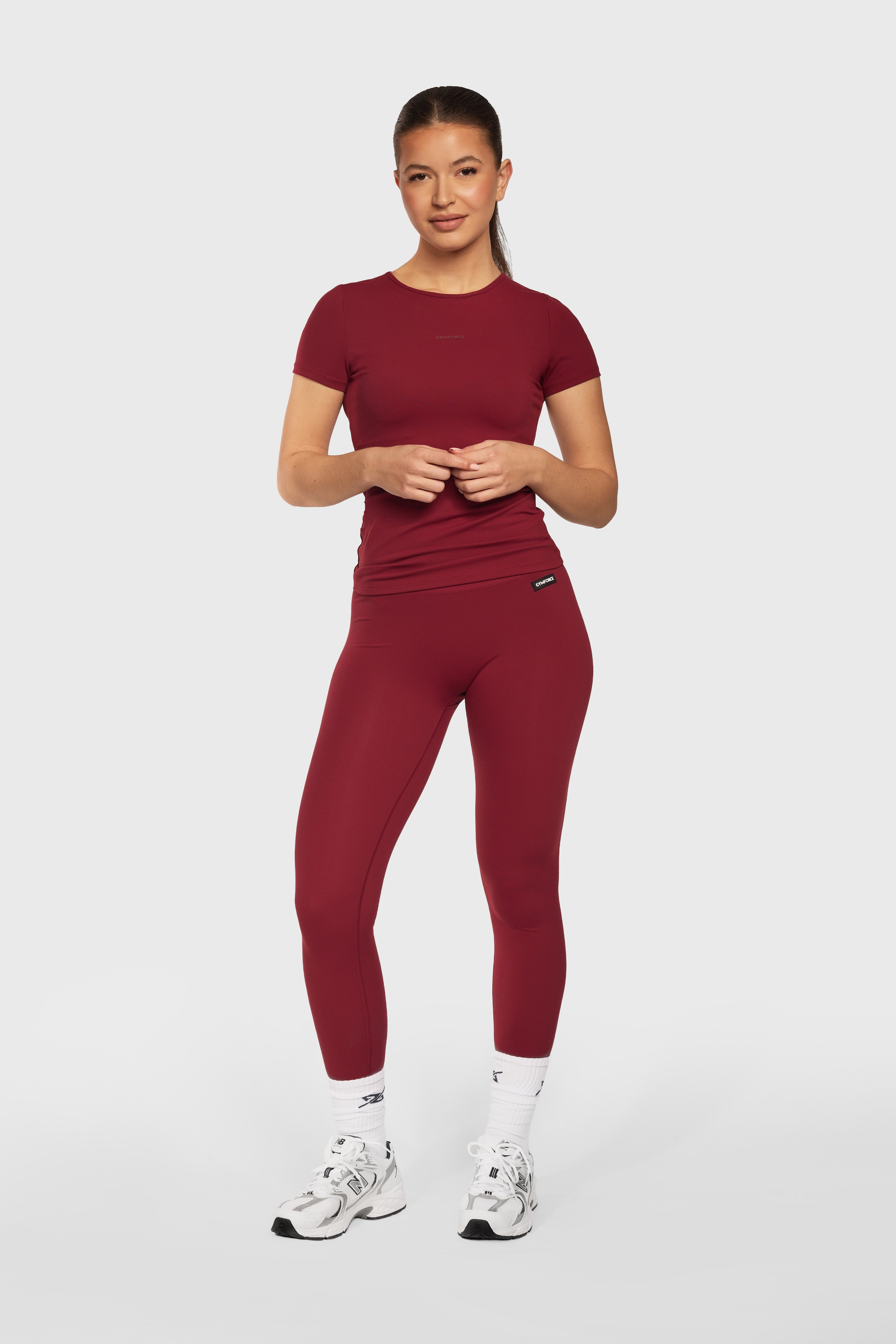 Model draagt de Burgundy Contour Legging en het Burgundy Contour T Shirt van Gymforce.