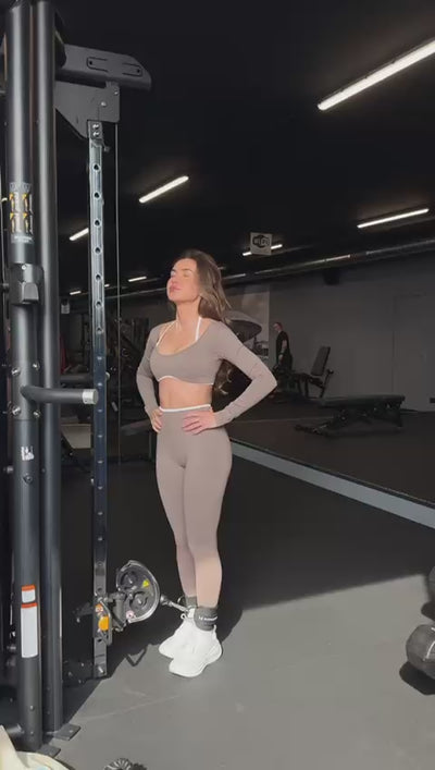 Model draagt de Mocha Sculpt Seamless Long Sleeve Top en Legging van Gymforce.