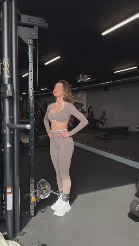 Model draagt de Mocha Sculpt Seamless Long Sleeve Top en Legging van Gymforce.